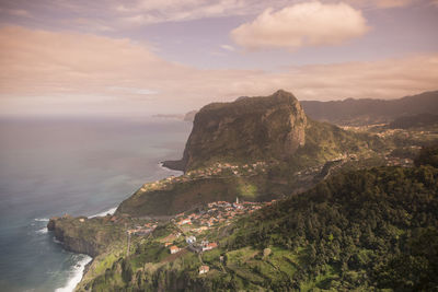 Scenic view of sea and mountains against sky