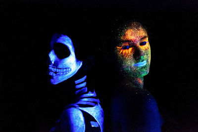 Portrait of man with multi colored light painting against black background