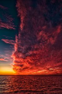 Scenic view of sea against dramatic sky during sunset