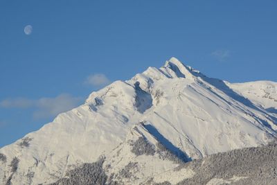 Low angle view of snow covered mountain against sky