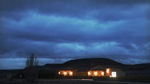 Scenic view of illuminated building against sky at night