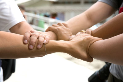 Cropped image of friends holding hands