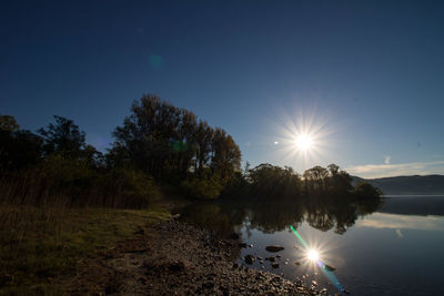 Scenic view of lake against bright sun