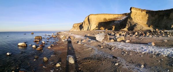 Rocks on beach against clear sky