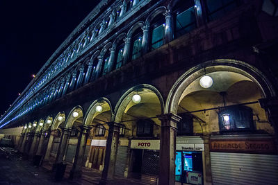 Low angle view of illuminated lights in city at night