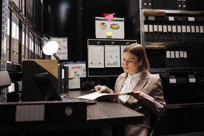 Young woman using laptop while sitting on table