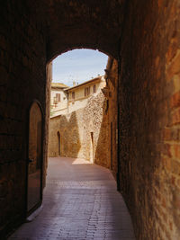 Narrow alley along old buildings in toscan