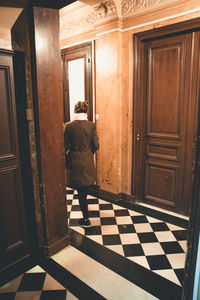 Rear view of man standing on door