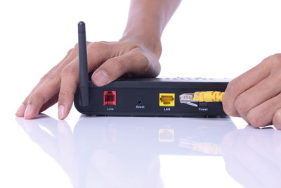 Midsection of man using smart phone against white background