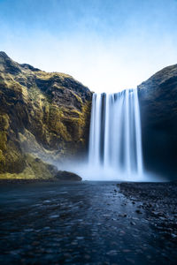 Scenic view of waterfall against sky