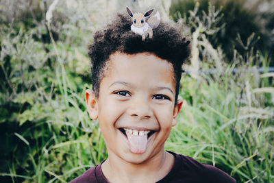 Close-up portrait of boy on grassy field