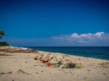 Scenic view of beach against blue sky