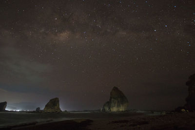 Scenic view of rock formation against sky at night