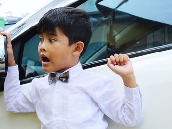 Boy looking away while sitting in car