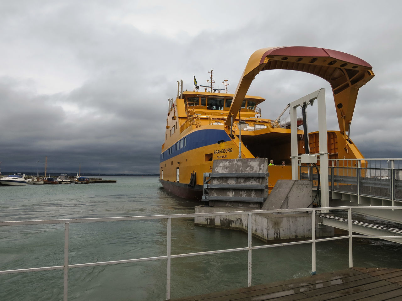 sky, water, cloud - sky, sea, built structure, architecture, transportation, nautical vessel, cloudy, mode of transport, cloud, pier, building exterior, outdoors, metal, incidental people, boat, day, railing, weather