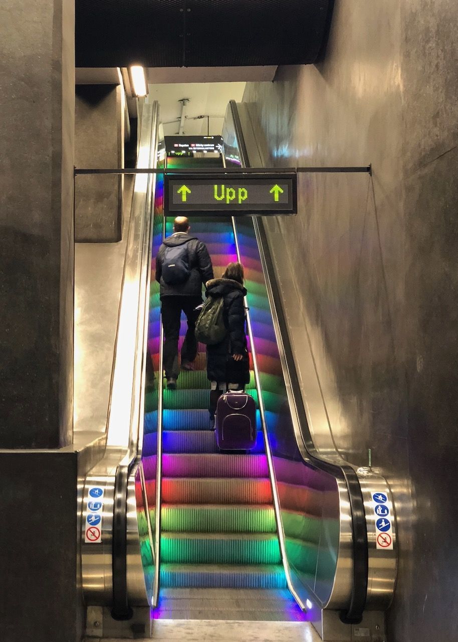 REAR VIEW OF PEOPLE ON ESCALATOR IN SUBWAY TRAIN