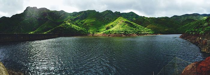 Scenic view of river and mountains against sky