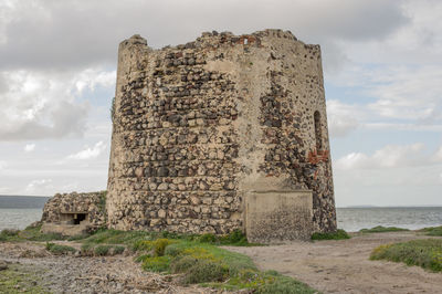 Stone wall by sea against sky