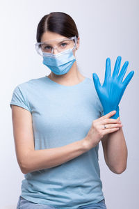 Portrait of young woman standing against white background