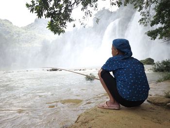 Rear view of woman looking at waterfall