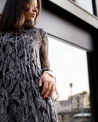 Thoughtful woman standing against wall