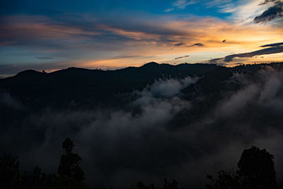 Scenic view of silhouette mountains against sky at sunset