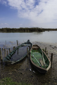 Abandoned boat moored on beach against sky