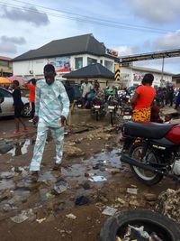 Rear view of people standing on road against sky