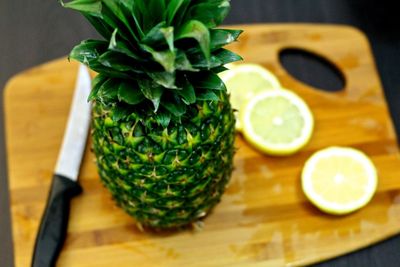 High angle view of pineapple with lime on cutting board