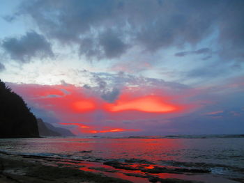 Scenic view of sea against dramatic sky during sunset