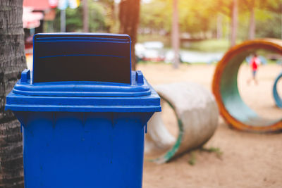 Blue garbage can on field