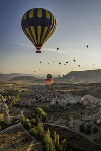 Hot air balloons flying against sky during sunset