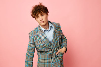 Portrait of young man against pink background