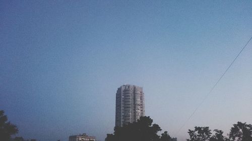 Low angle view of skyscrapers against clear blue sky