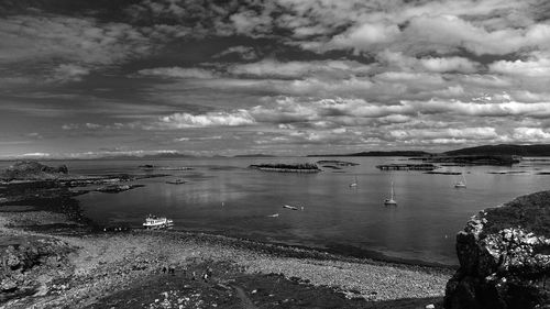 Idyllic view of sea against cloudy sky