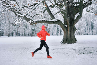 Running woman, girl runner on snow in park winter day. run, sport concept, leisure and freedom.