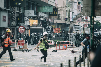 People on street against buildings in city