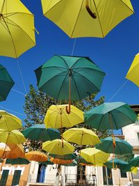 Low angle view of umbrellas hanging against sky