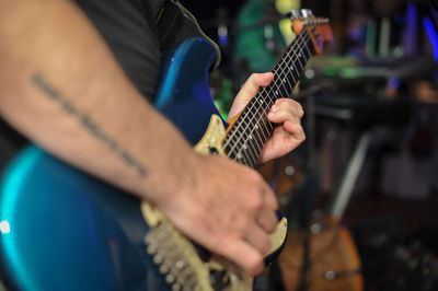 Midsection of man playing guitar