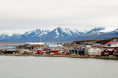 Scenic view of snowcapped mountains by sea against sky