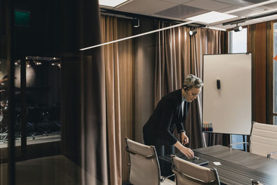 Businesswoman in board room seen through glass wall