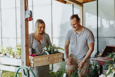 Smiling couple choosing flowers in shop