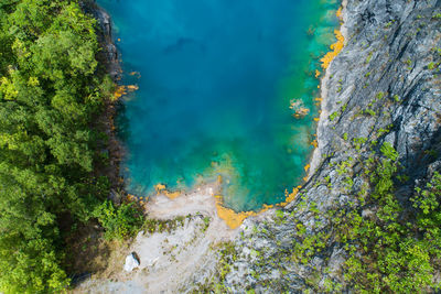 Aerial view of amazing pond in tropical rainforest forest with mountain rocks peak 