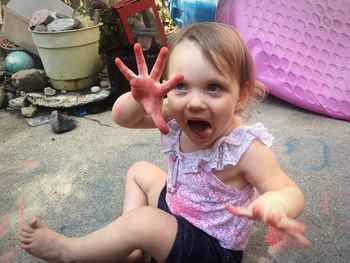 Playful girl sitting on footpath