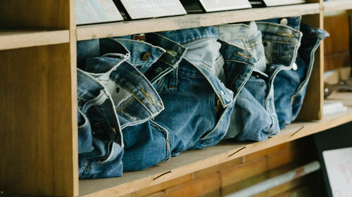 Close-up of jeans in shelf at store for sale