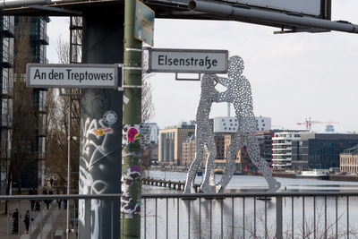 Information sign in city against sky