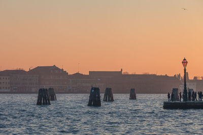 View of buildings at waterfront during sunset