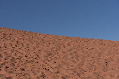 Scenic view of desert against clear blue sky