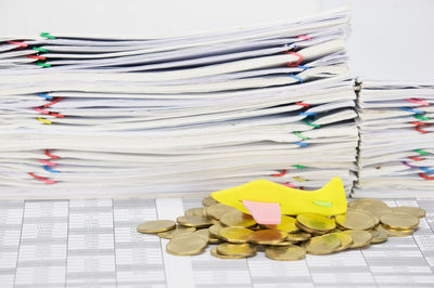 High angle view of airplane model on coins by stacked files