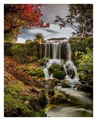 Scenic view of waterfall against sky